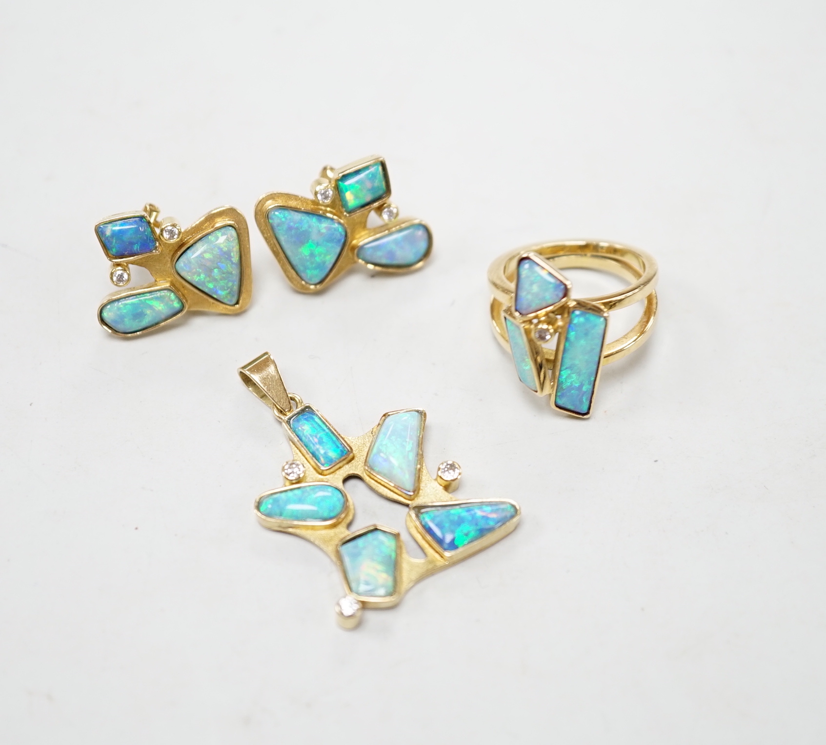 A modernist suite of 750 yellow metal, opal doublet? and diamond cluster set jewellery, comprising a pendant (overall 37mm), dress ring and pair of earrings, gross weight 24 grams.